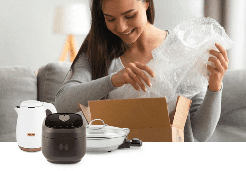 Smiling woman opening box with Aroma products in the foreground